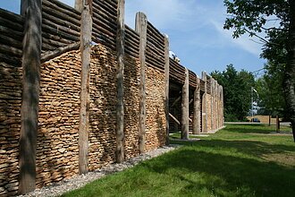 Das rekonstruierte Keltentor ist aus vielen Holzpflöckengebaut, die mit Steinen ausgefüllt sind. Und oben wurde die Konstruktion mit Holzlatten noch weiter erhöht.