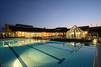 Limes Therme Bad Gögging Die Therme und das Außenbecken hell erleuchtet in der Nacht.
