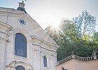 Zwei Frauen und ein Mann stehen vor der Kirche im Klosterinnenhof und bestaunen das Gebäude von außen.