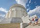 Zwei Frauen und ein Mann, in sommerlicher Kleidung, steigen die Treppen der Befreiungshalle hinunter und werfen einen letzten Blick zu ihr hinauf. Der Himmel strahlt blau und ein paar Wolken sind zu sehen.